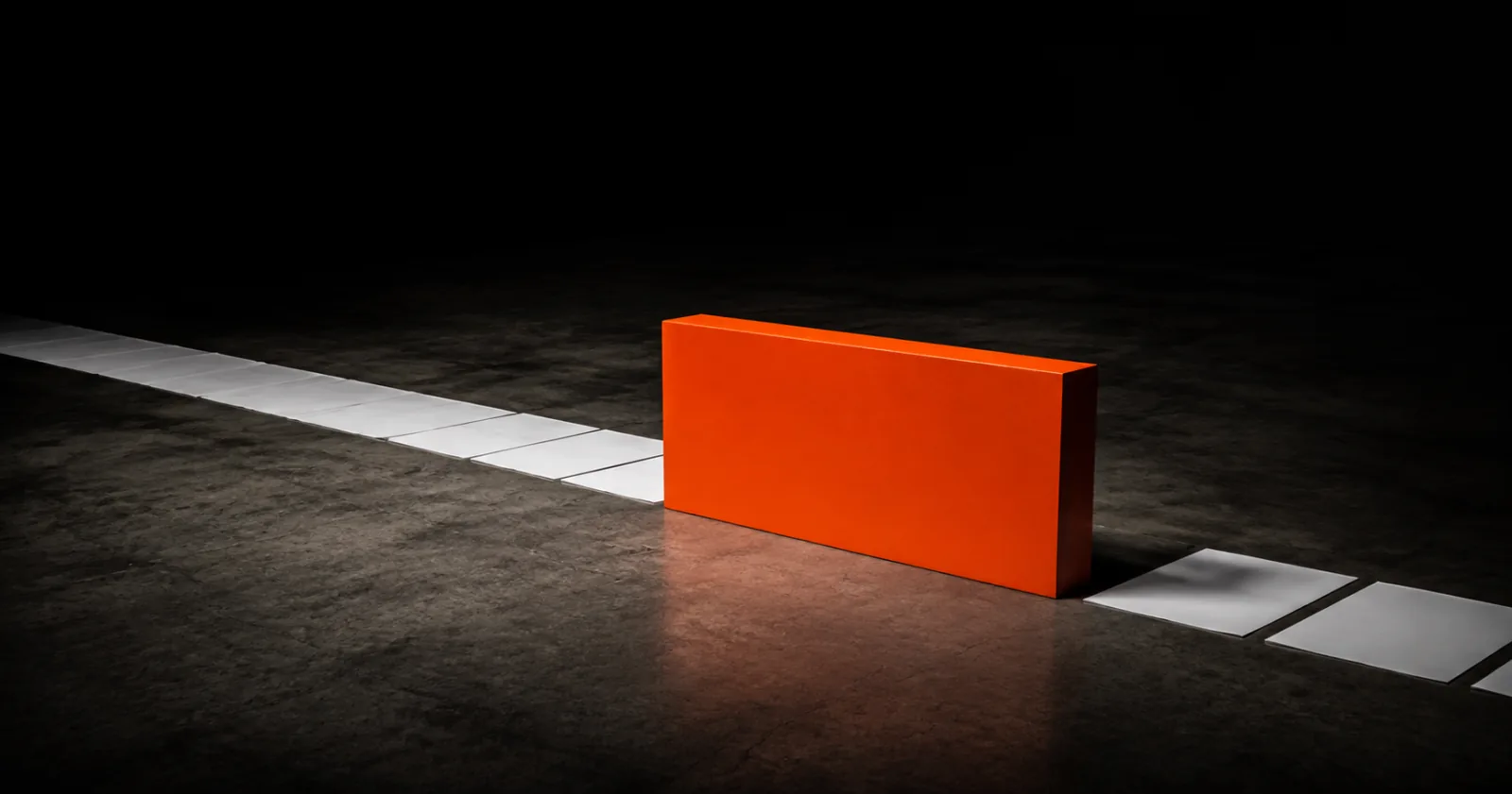 An orange block placed in the middle of a line of white tiles, interrupting it