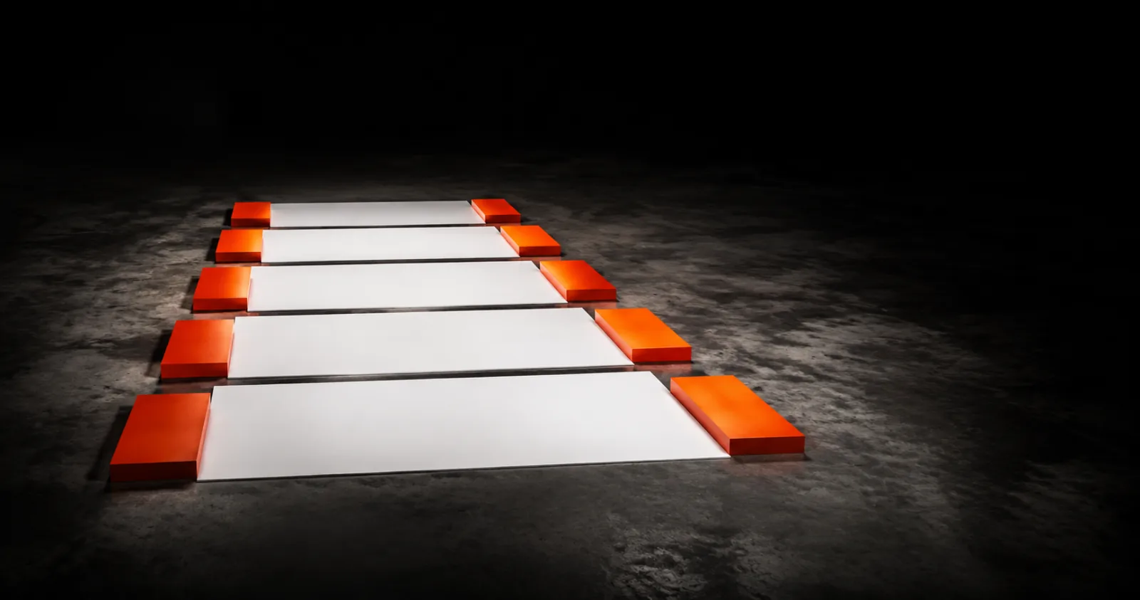Five white slabs in a row, each capped at both ends by an orange block